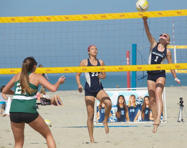 Cady Francis, beach volleyball player, hits a ball over the net.