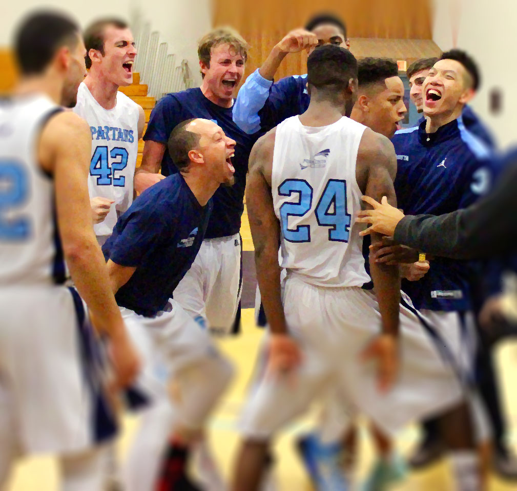 Men's Basketball team in a huddle cheering before the game.