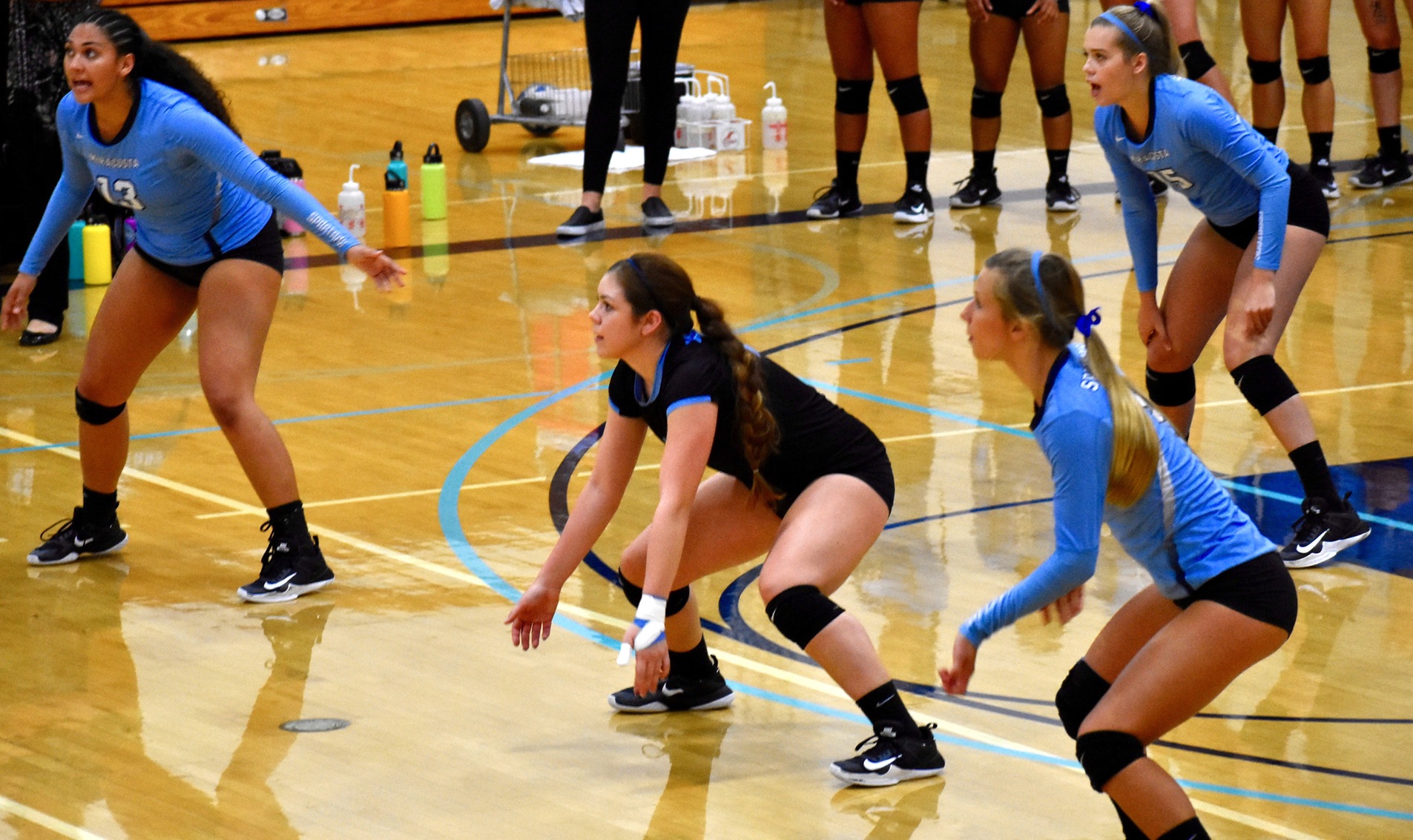 Women's Volleyball team playing defense.